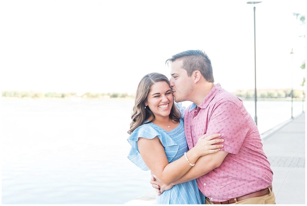 engaged couple snuggling kissing giggling by lake and canals in las colinas texas