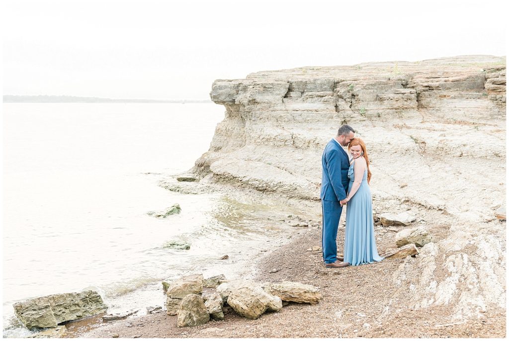 engaged couple by cliff at rockledge park in grapevine texas blue dress