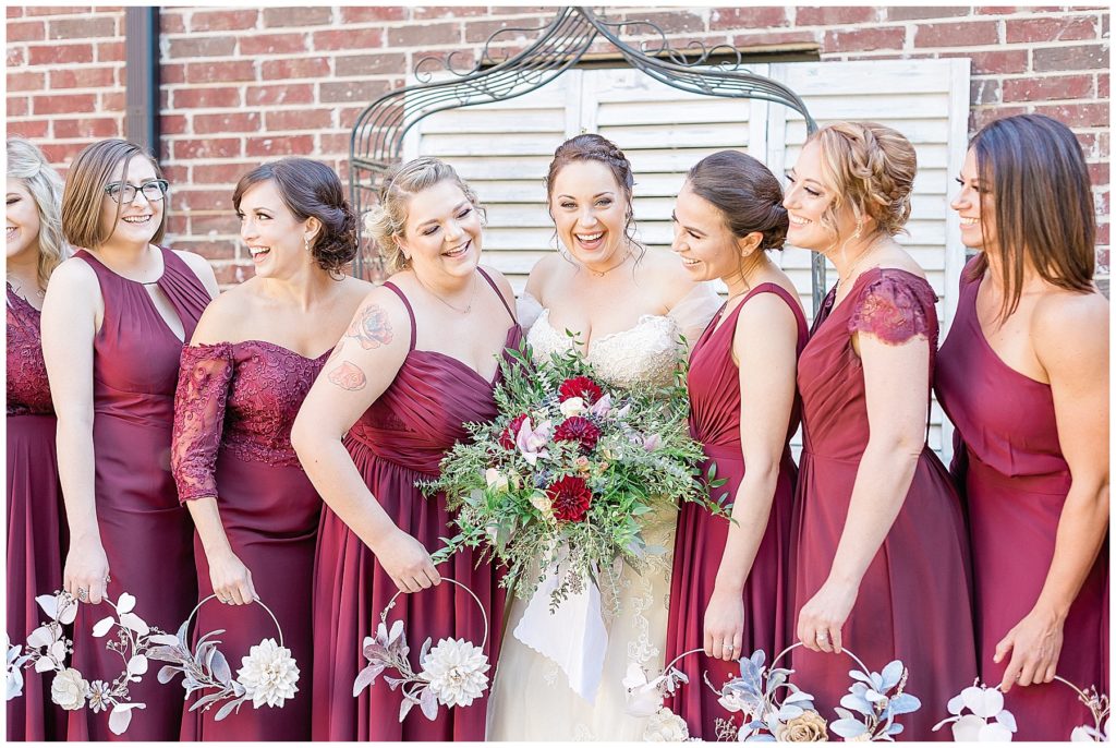 bride laughing with bridesmaids burgundy bridesmaid dresses