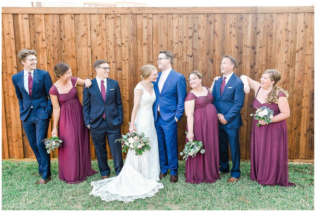 wedding party in navy suits and burgundy dresses