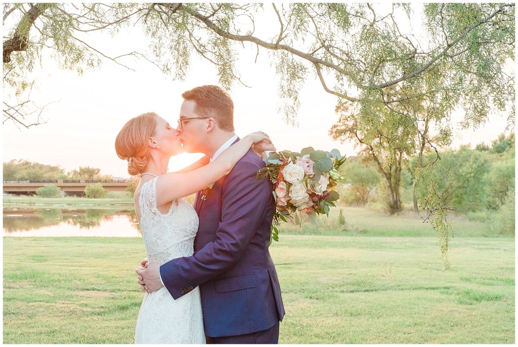 bride and groom kissing at sunset golden hour