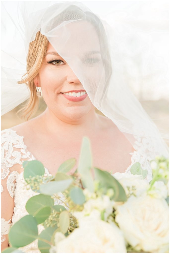 bride under veil peep with white rose bouquet
