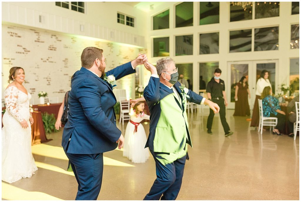 groom and father in law dancing at wedding reception