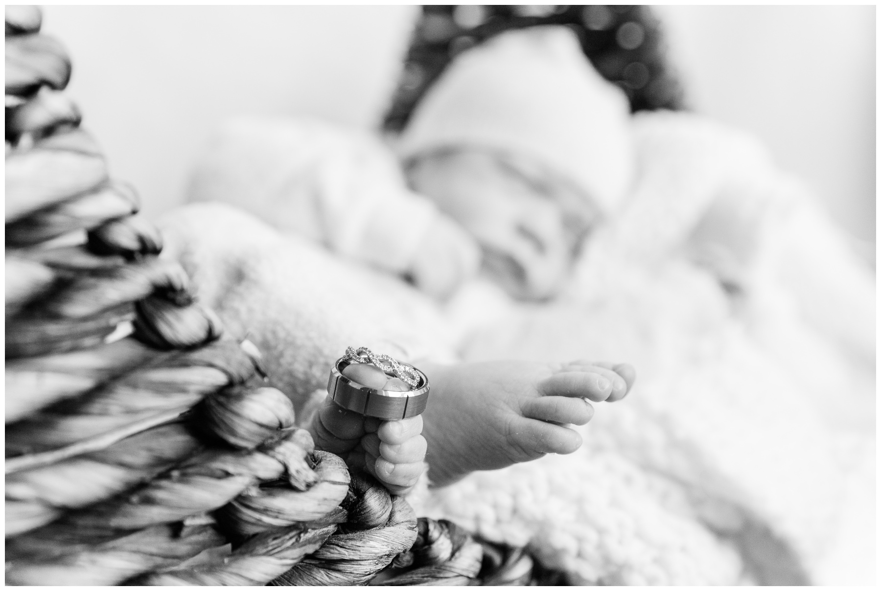 baby lays on bed in cap during newborn photos