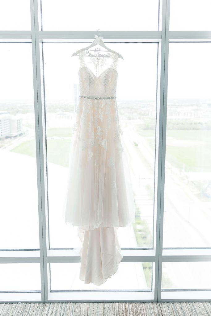 wedding dress hangs in window of Omni Hotel
