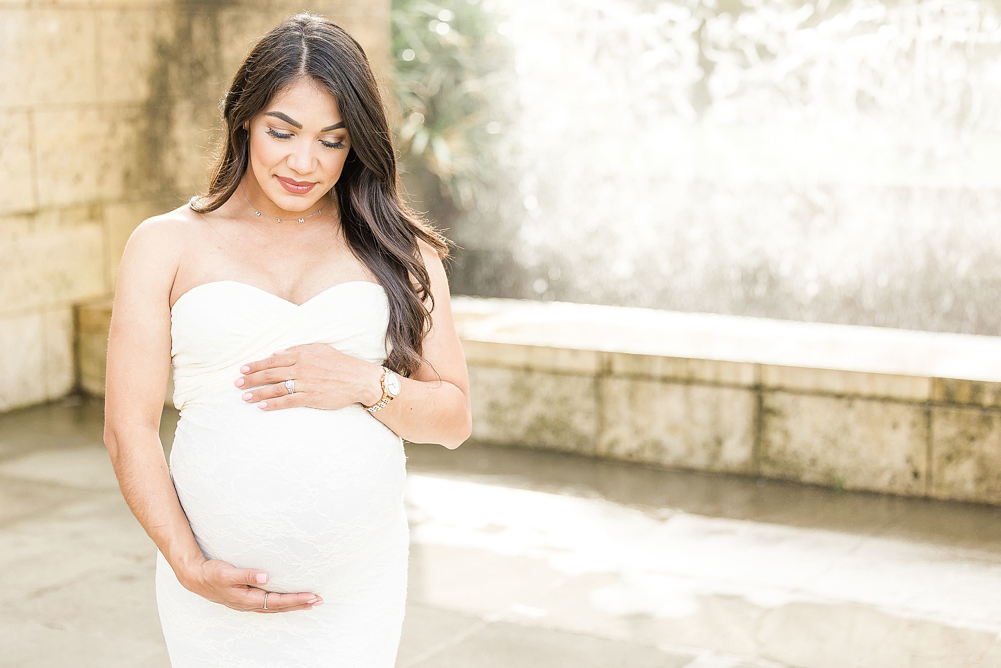 mom-to-be holds belly in white gown during Dallas Arboretum maternity session