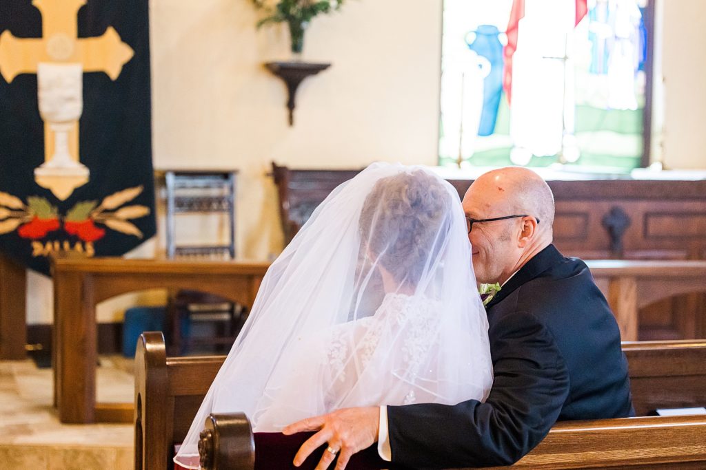 groom looks at bride during traditional church wedding at the Church of Holy Communion