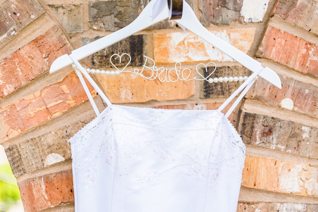 bride's wedding dress hangs on custom hanger 