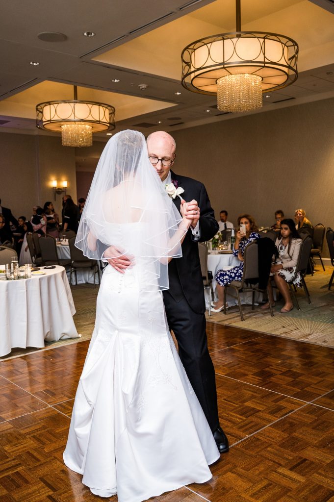 groom dances with bride during wedding reception at Dallas Addison Marriott