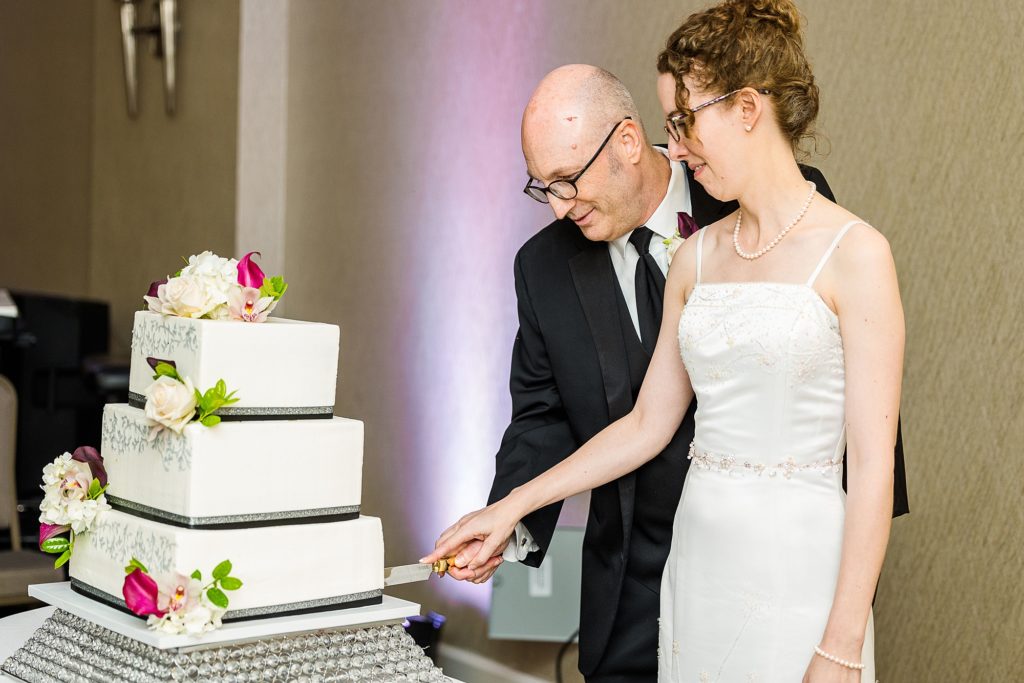 bride and groom cut wedding cake at the Dallas Addison Marriott