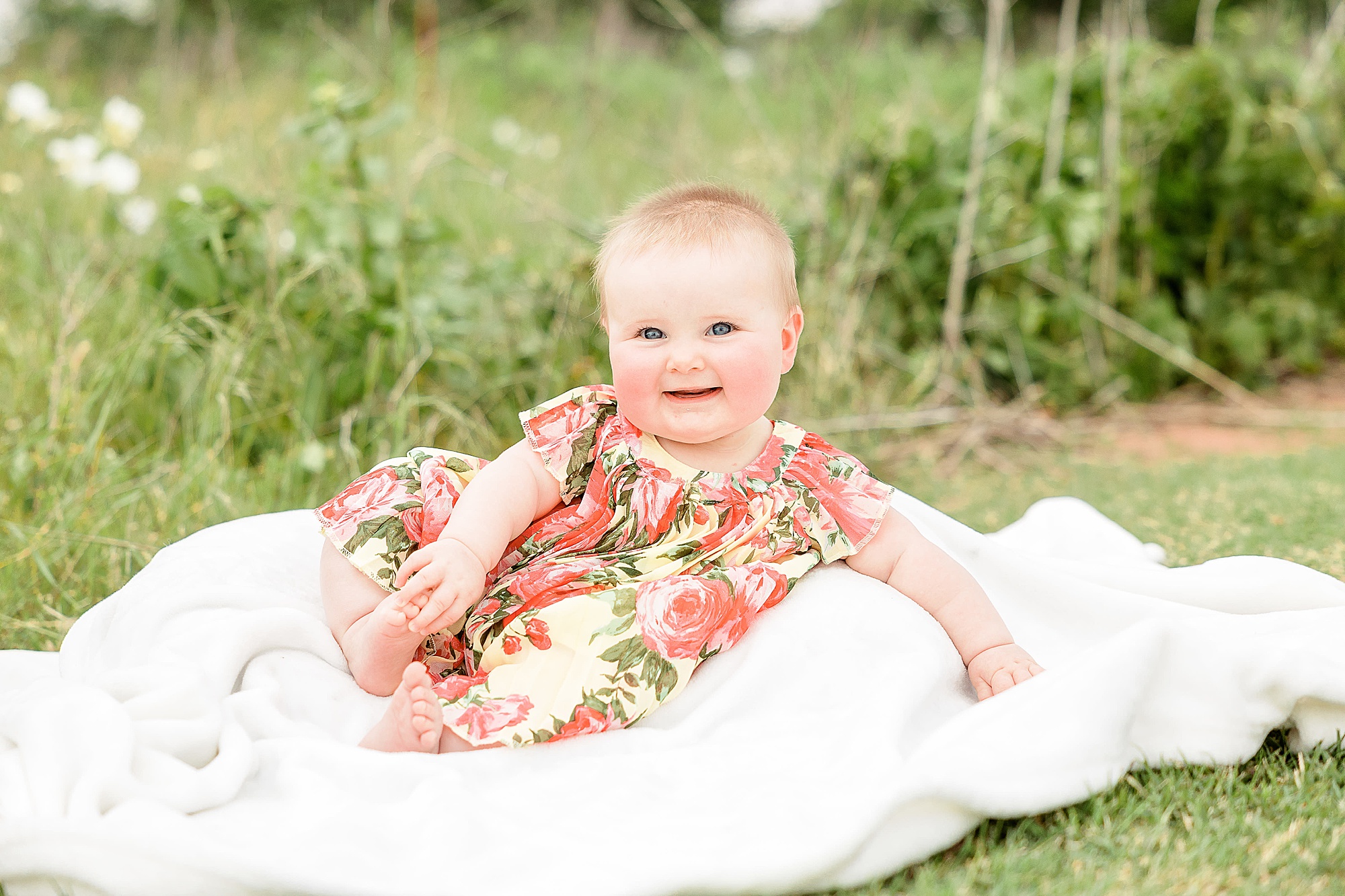 toddler lays on blanket during Little Elm family portraits
