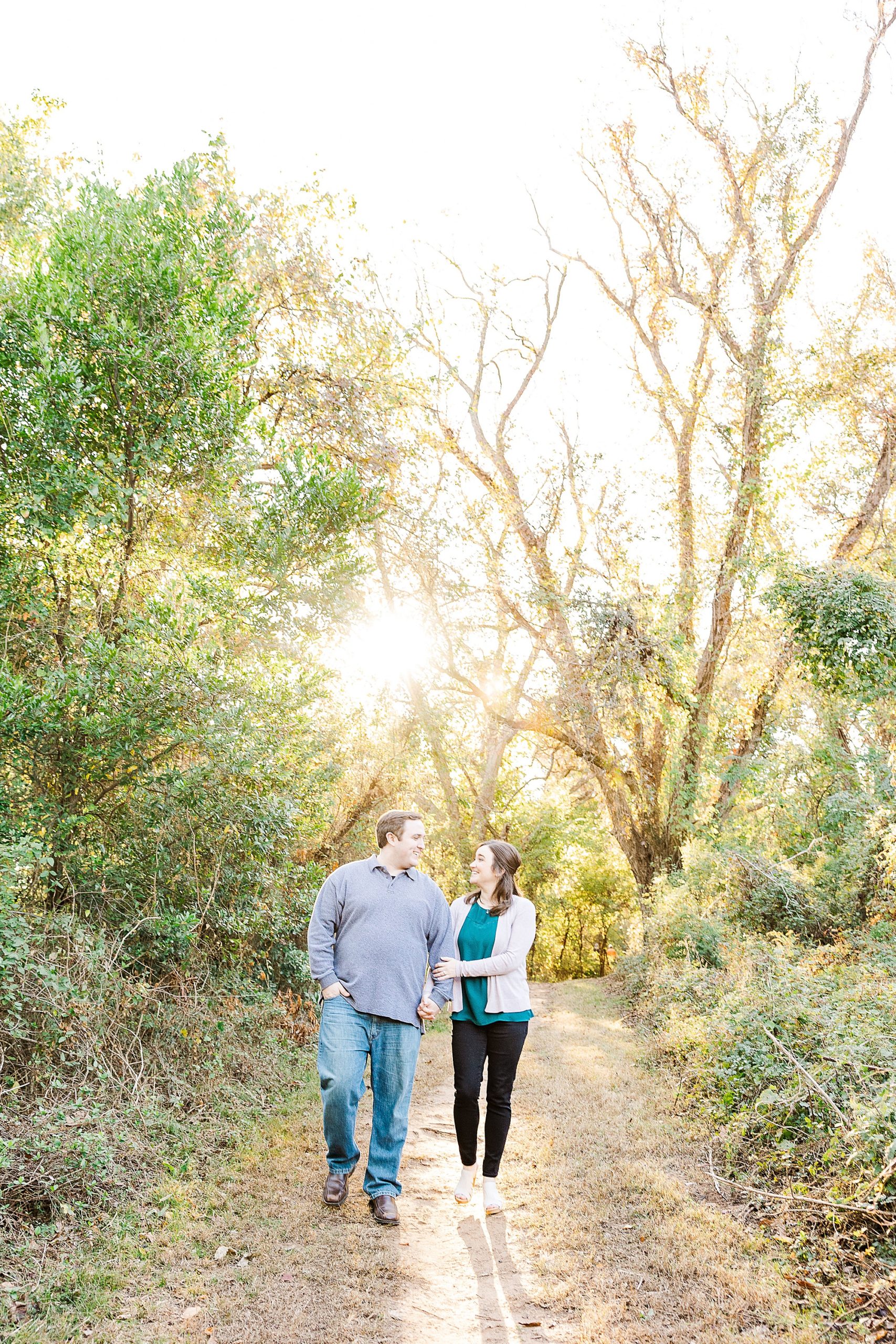 engaged couple walks down path during fall Shreveport engagement session