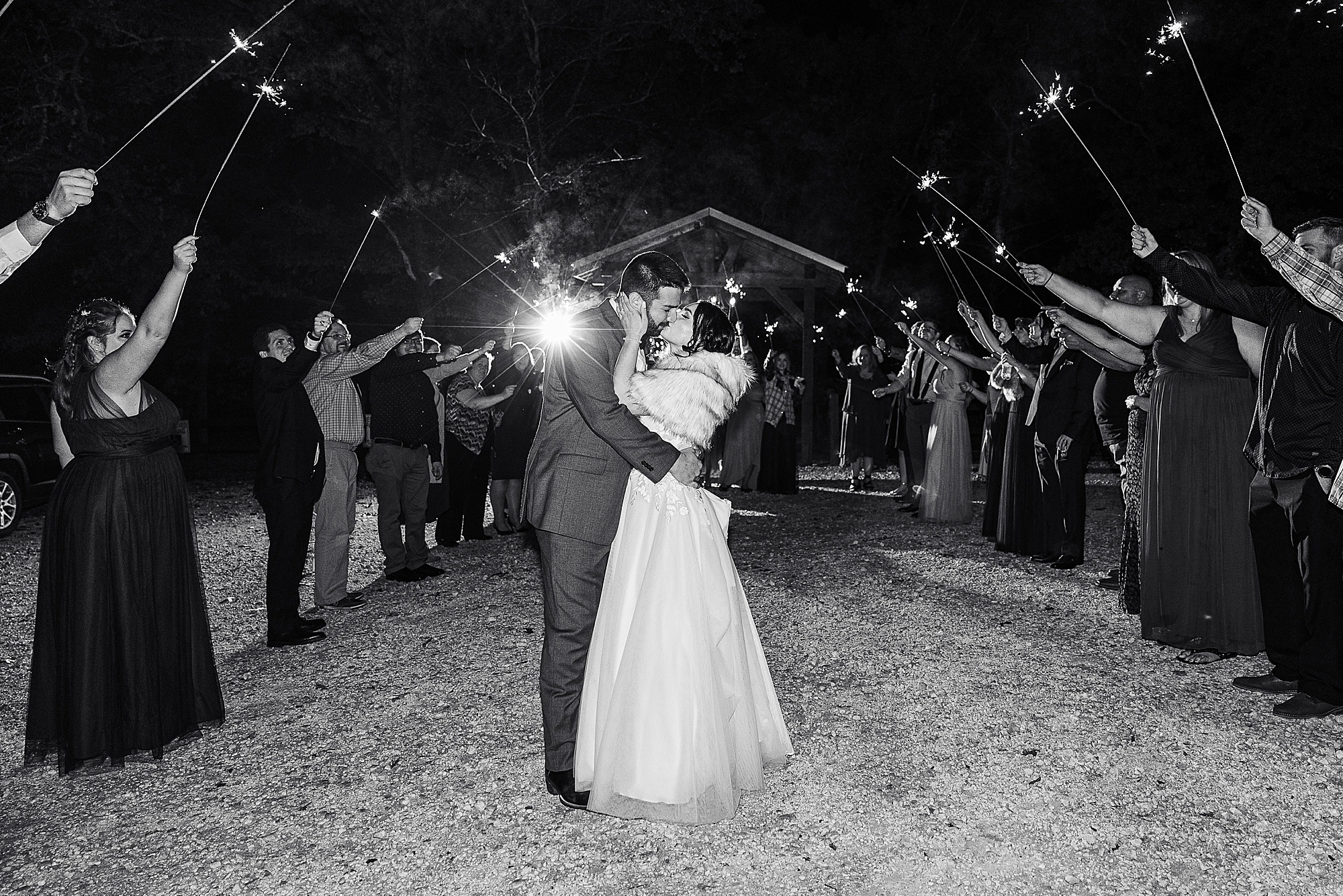 groom kisses bride during sparkler exit