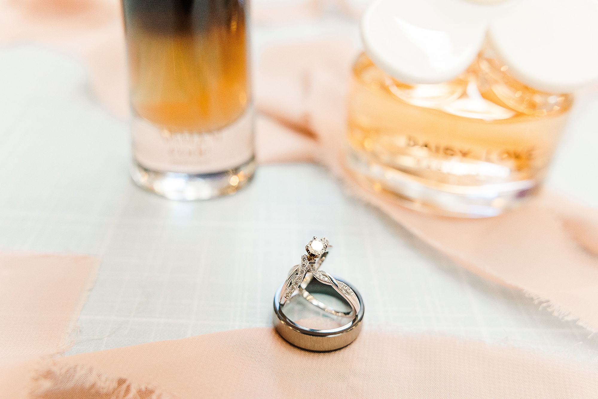 wedding rings rest by perfume bottle
