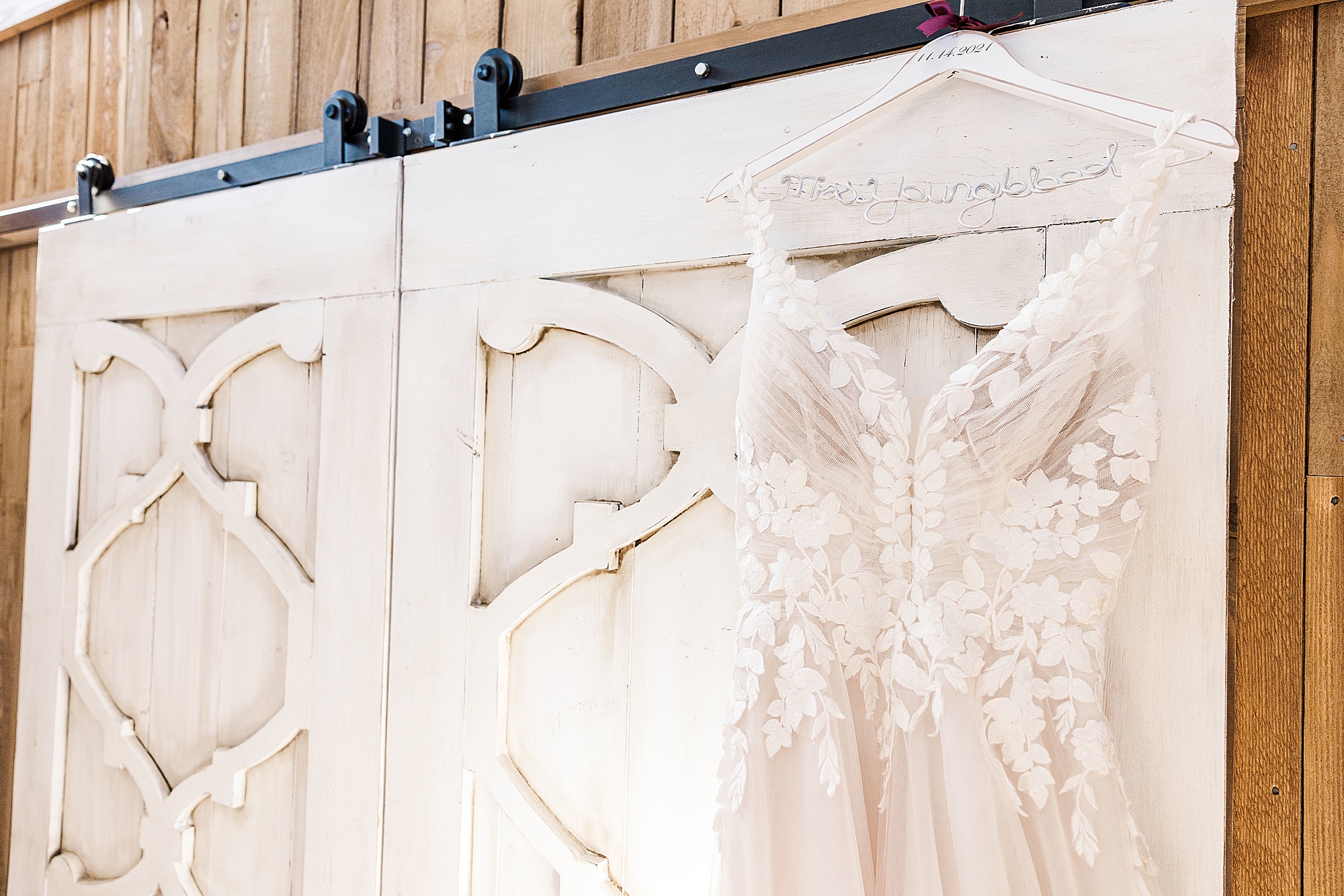 wedding dress hangs on white door at Whispering Oaks
