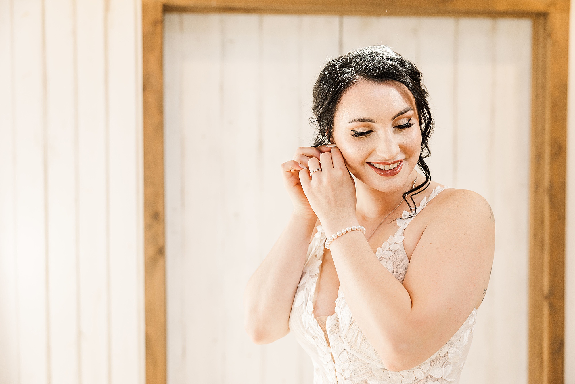 bride puts on earrings for TX wedding