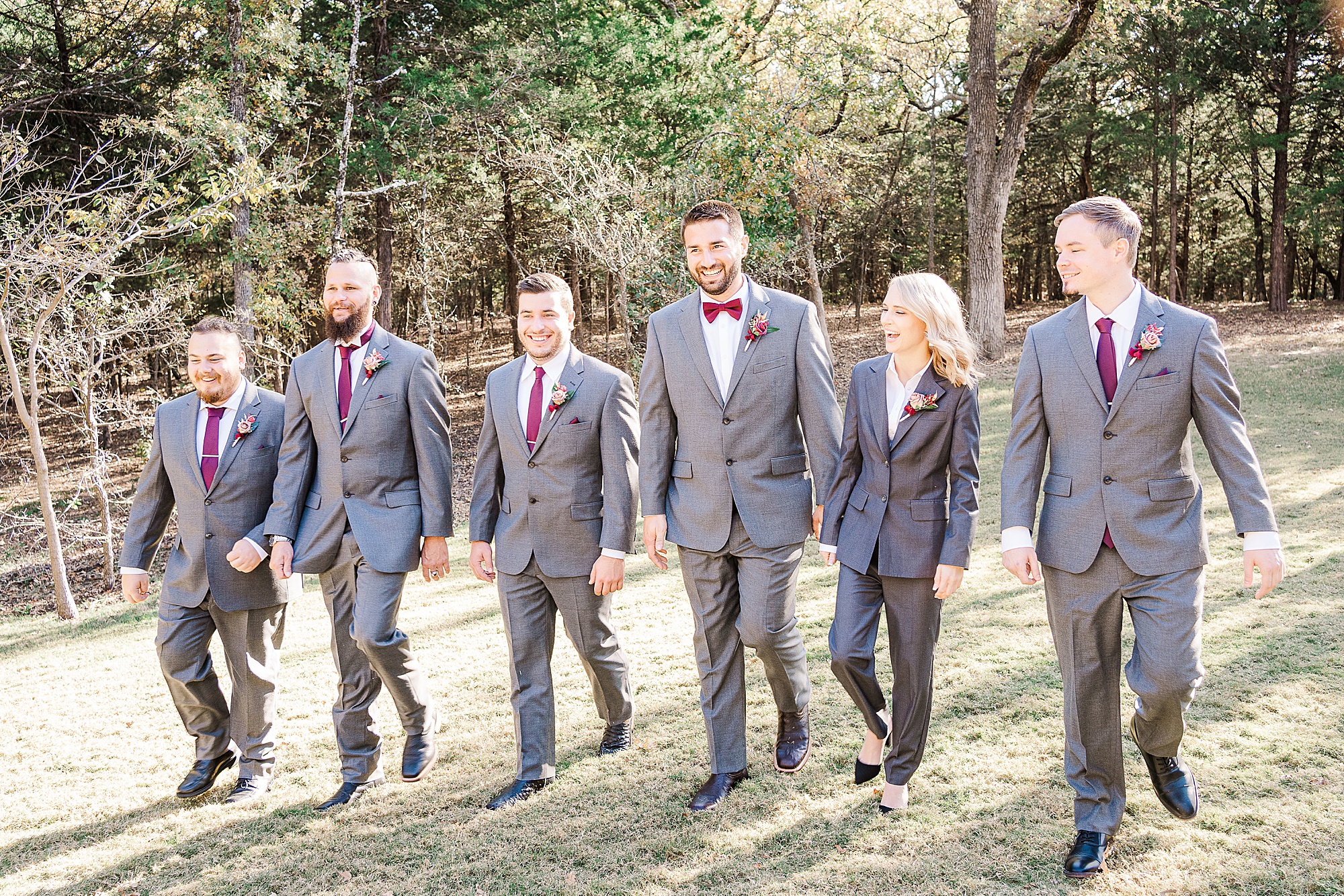 groom walks with groomsmen in grey suits at Whispering Oaks