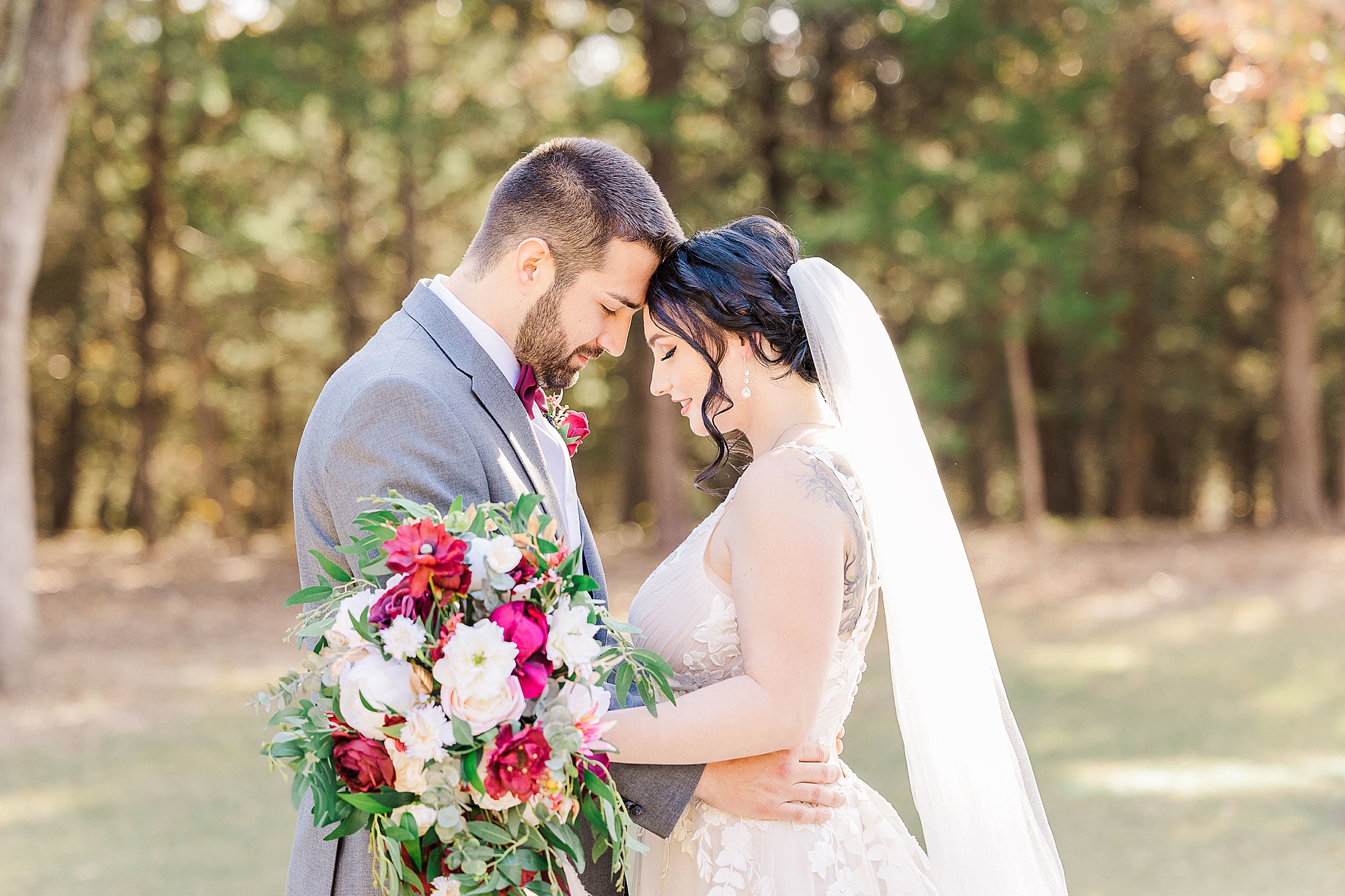 newlyweds stand with foreheads touching during portraits at Whispering Oaks