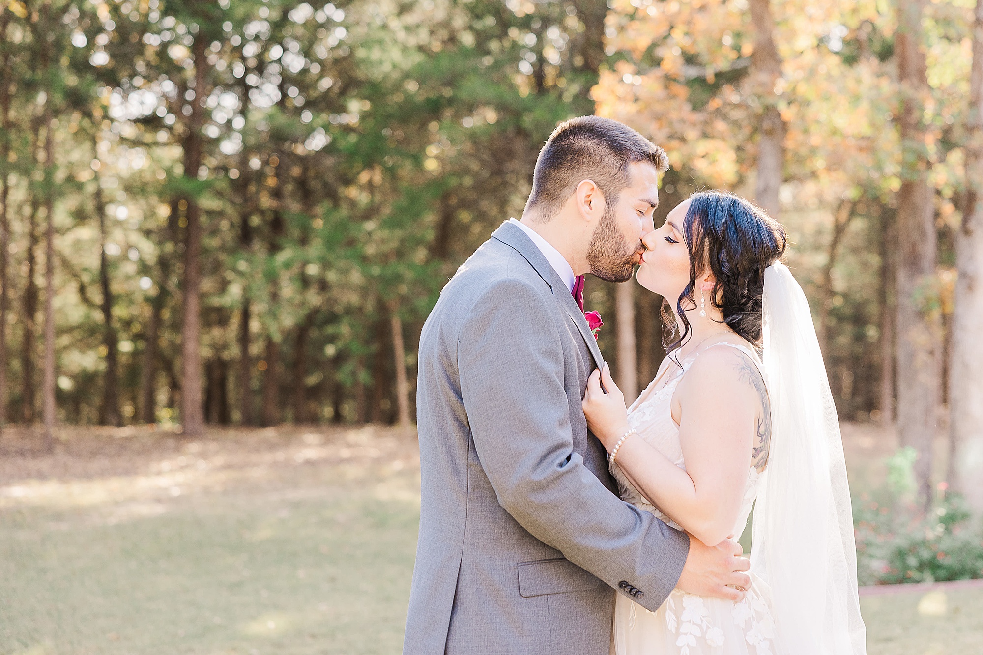 bride and groom kiss during portraits at Whispering Oaks