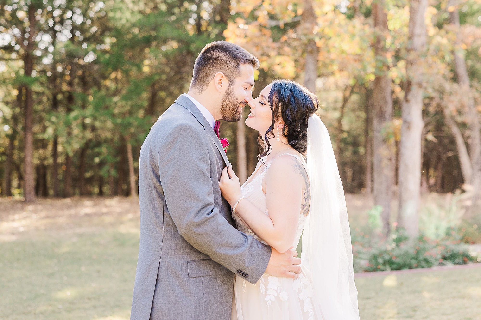 newlyweds lean for a kiss during portraits at Whispering Oaks