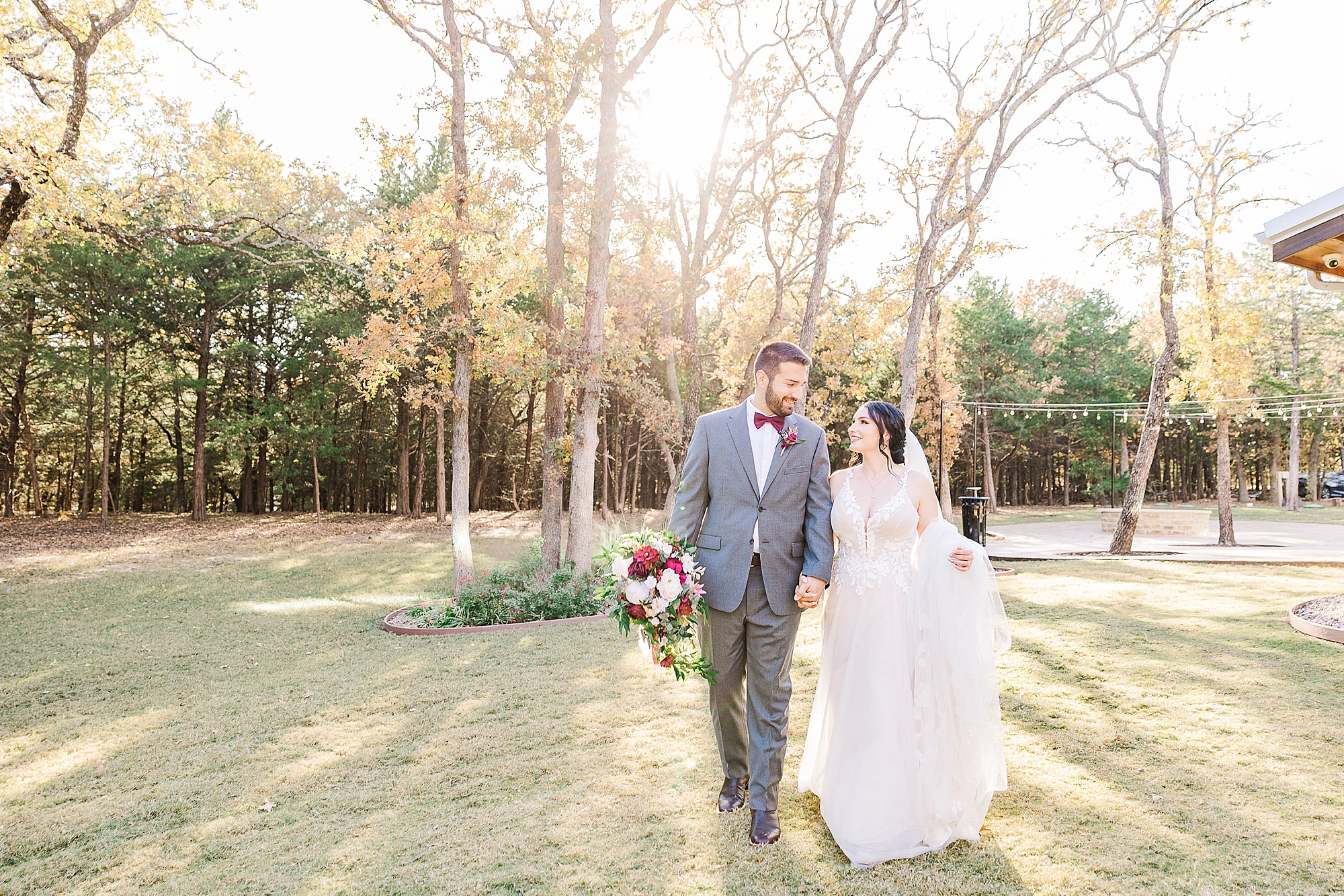 bride and groom hold hands walking together at Whispering Oaks
