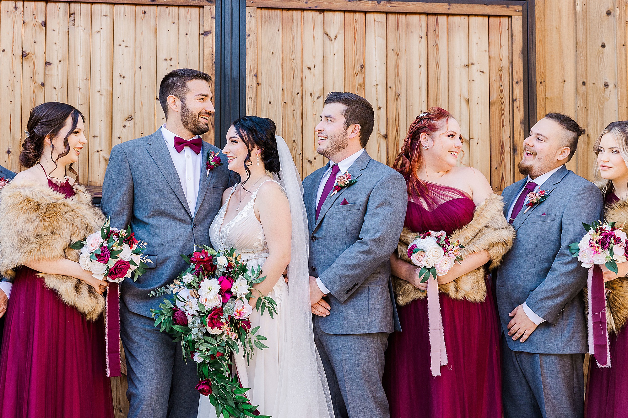 bride and groom laugh together during Whispering Oaks photos with wedding party