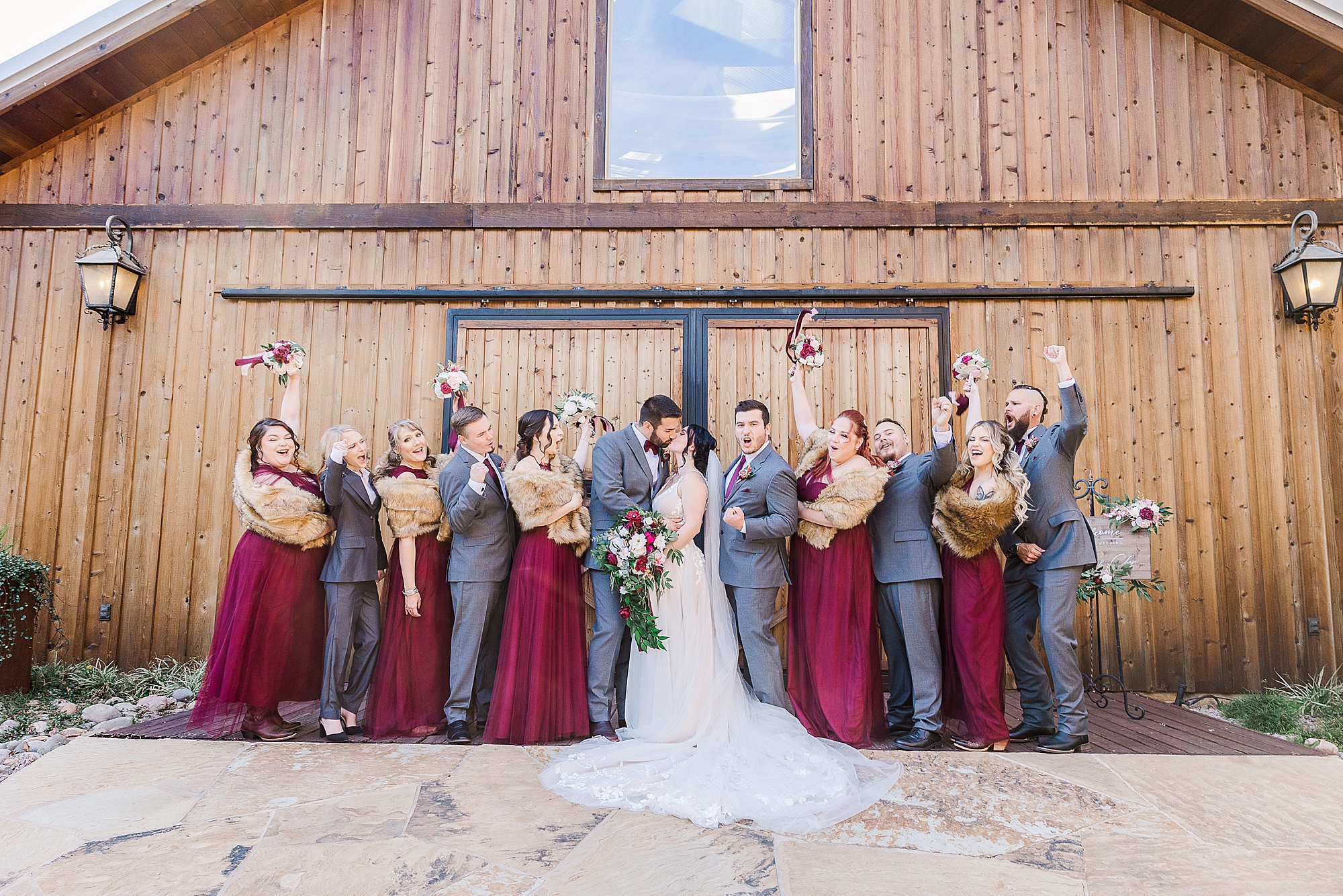bride and groom kiss while wedding party cheers in North Texas