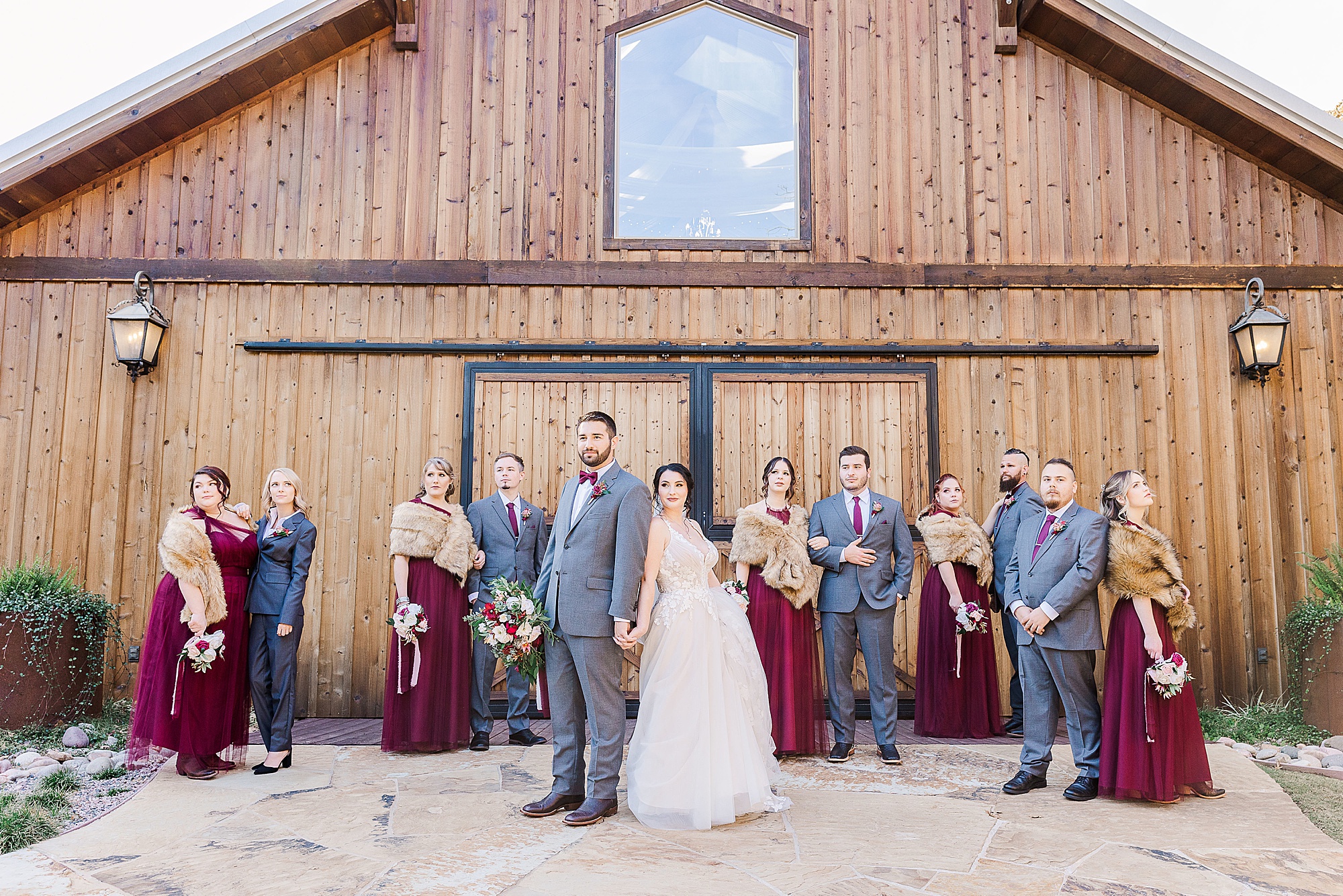 bride and groom stand back to back with wedding party