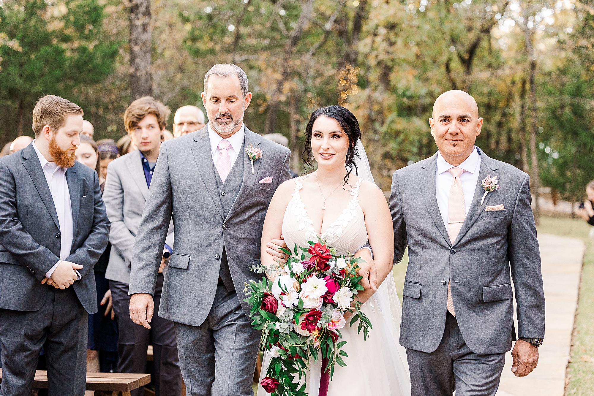 bride walks up aisle with dad and step-dad
