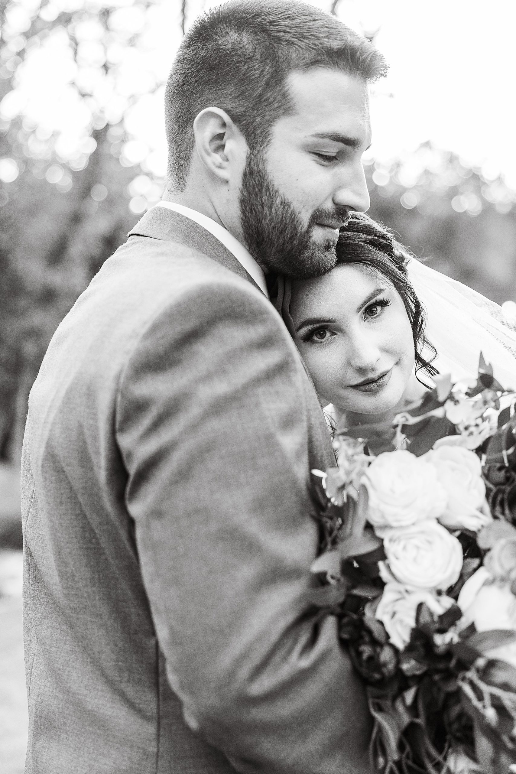bride leans on groom's chest during portraits at Whispering Oaks