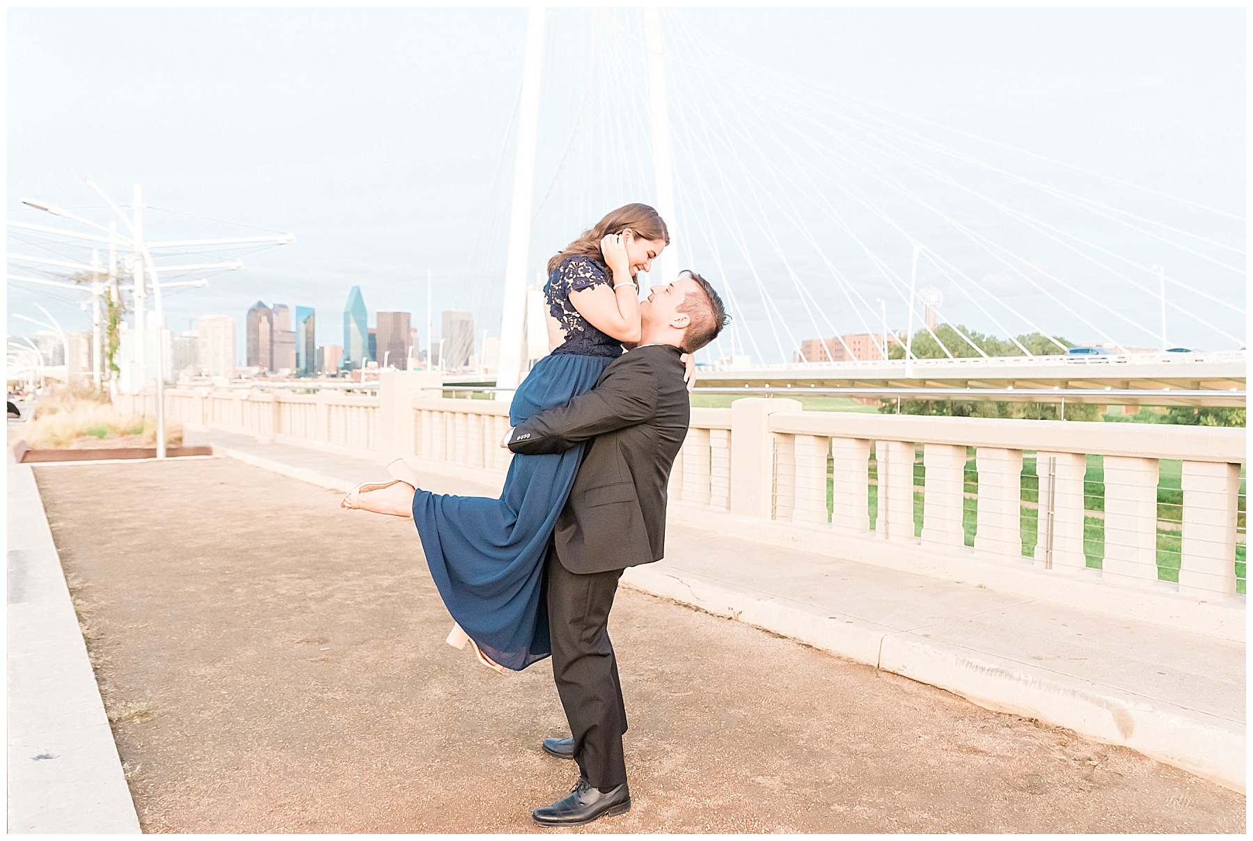 couple at Margaret hunt hill bridge dallas texas skyline navy dress black suit