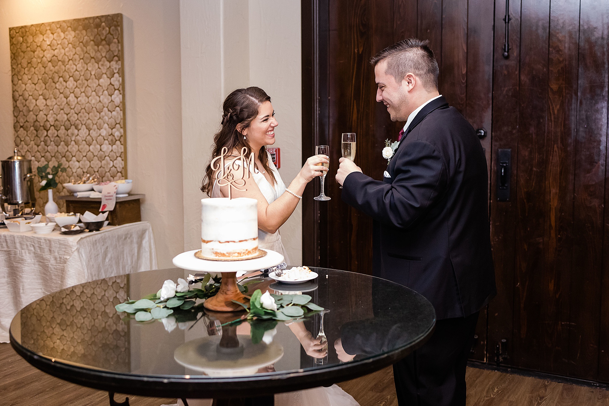 newlyweds toast with champagne before cutting cake 