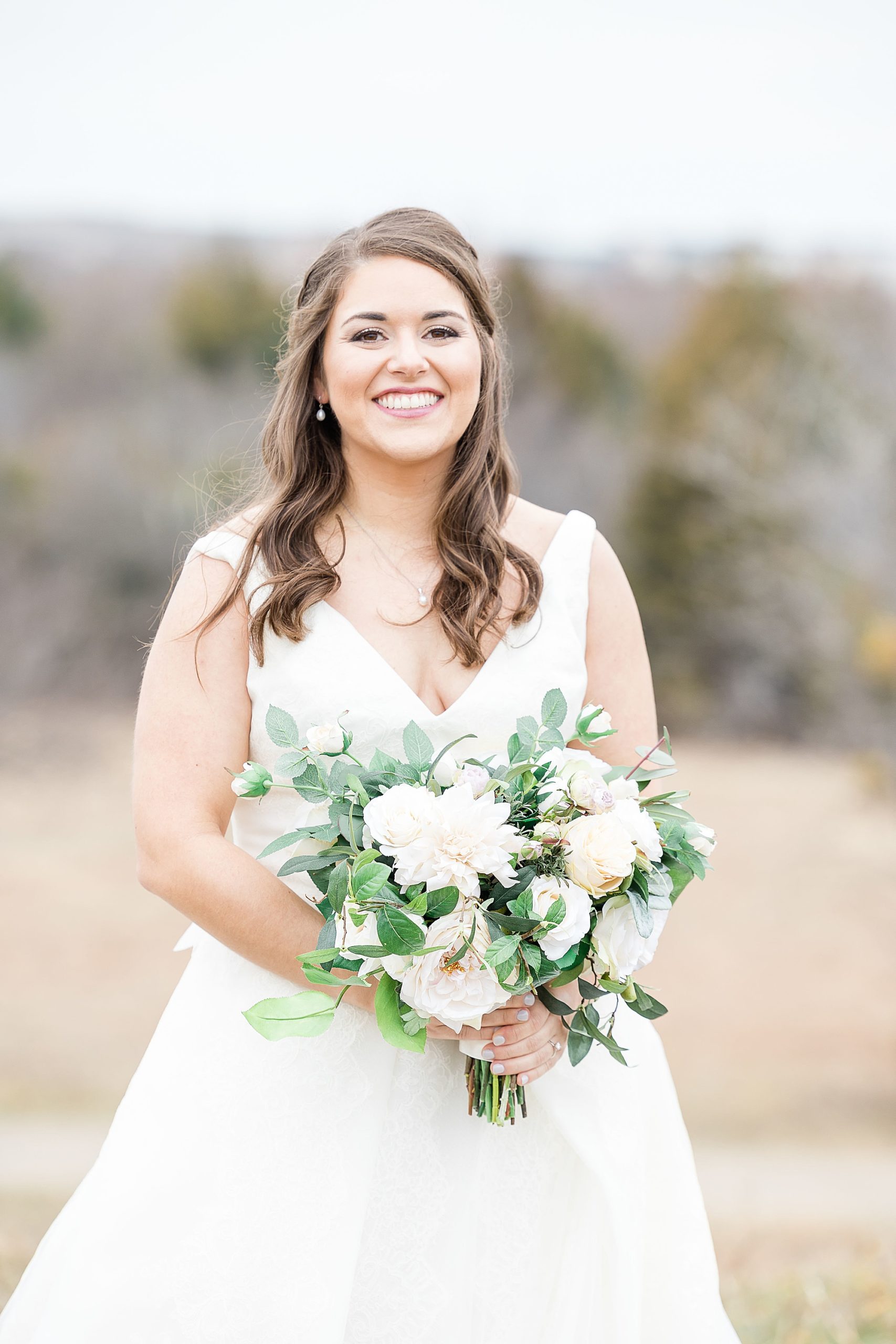 bride laughs holding bouquet of pastel flowers 