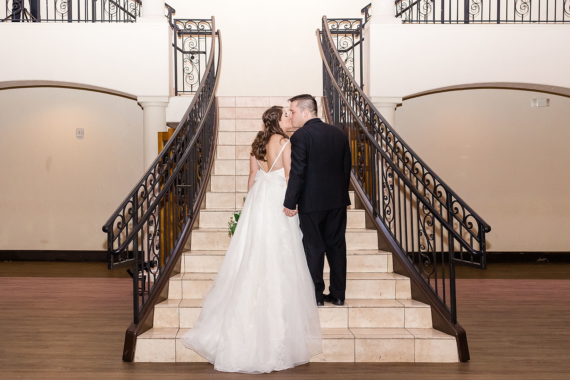 newlyweds kiss on steps at Chapel at Ana Villa