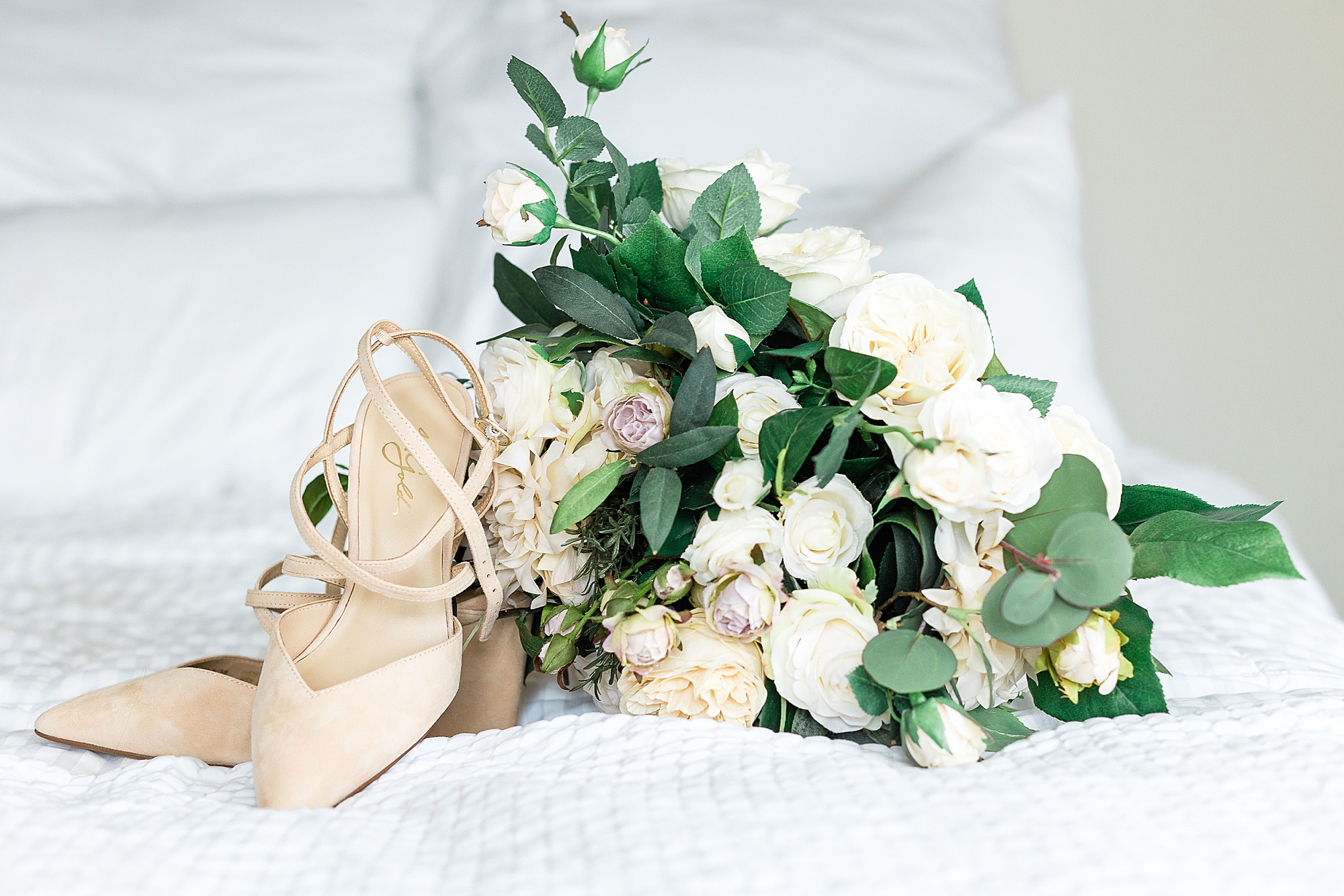 bride's bouquet sits on bed of Courtyard Marriott in Colony TX
