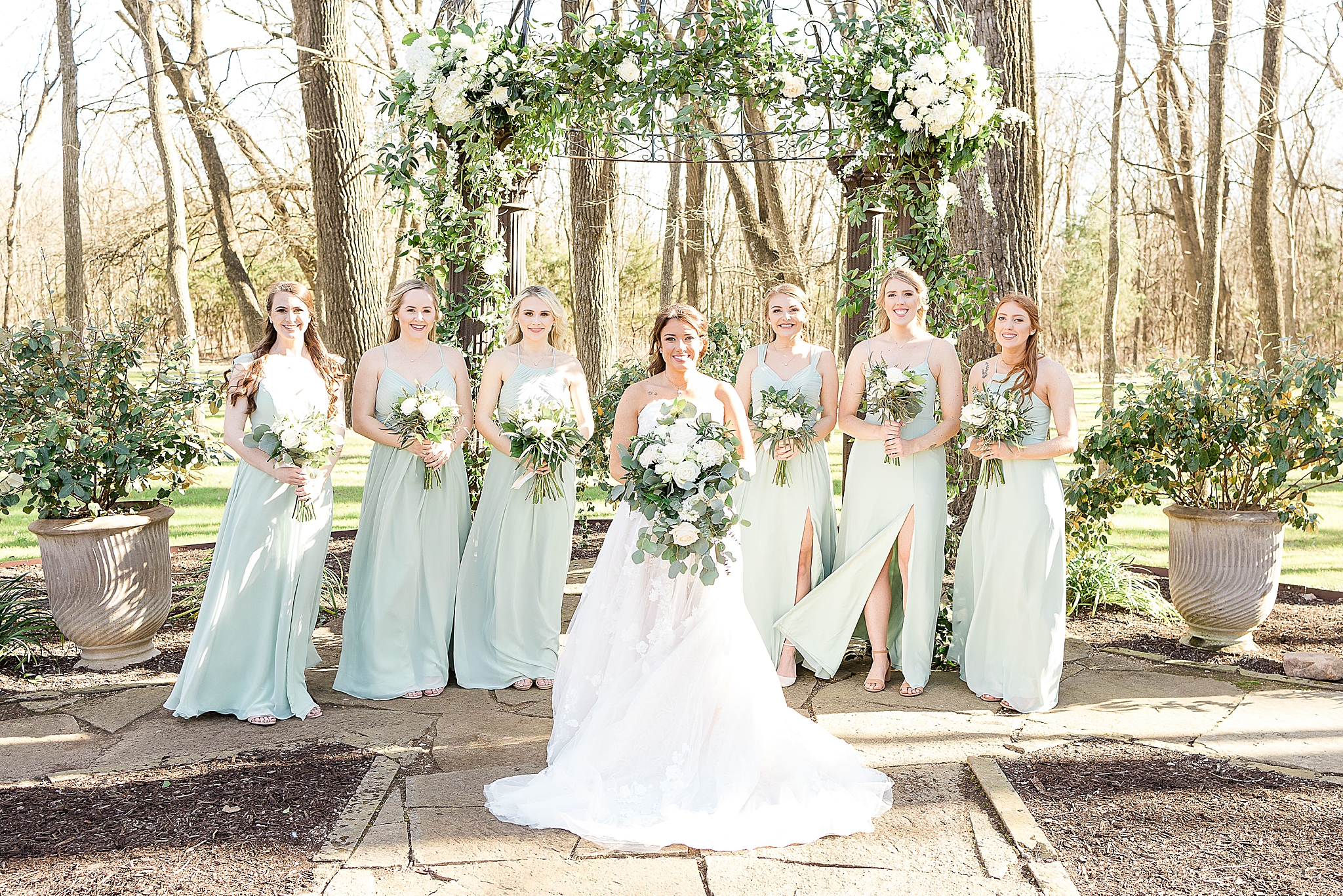 bridesmaids in teal green dresses pose with bride