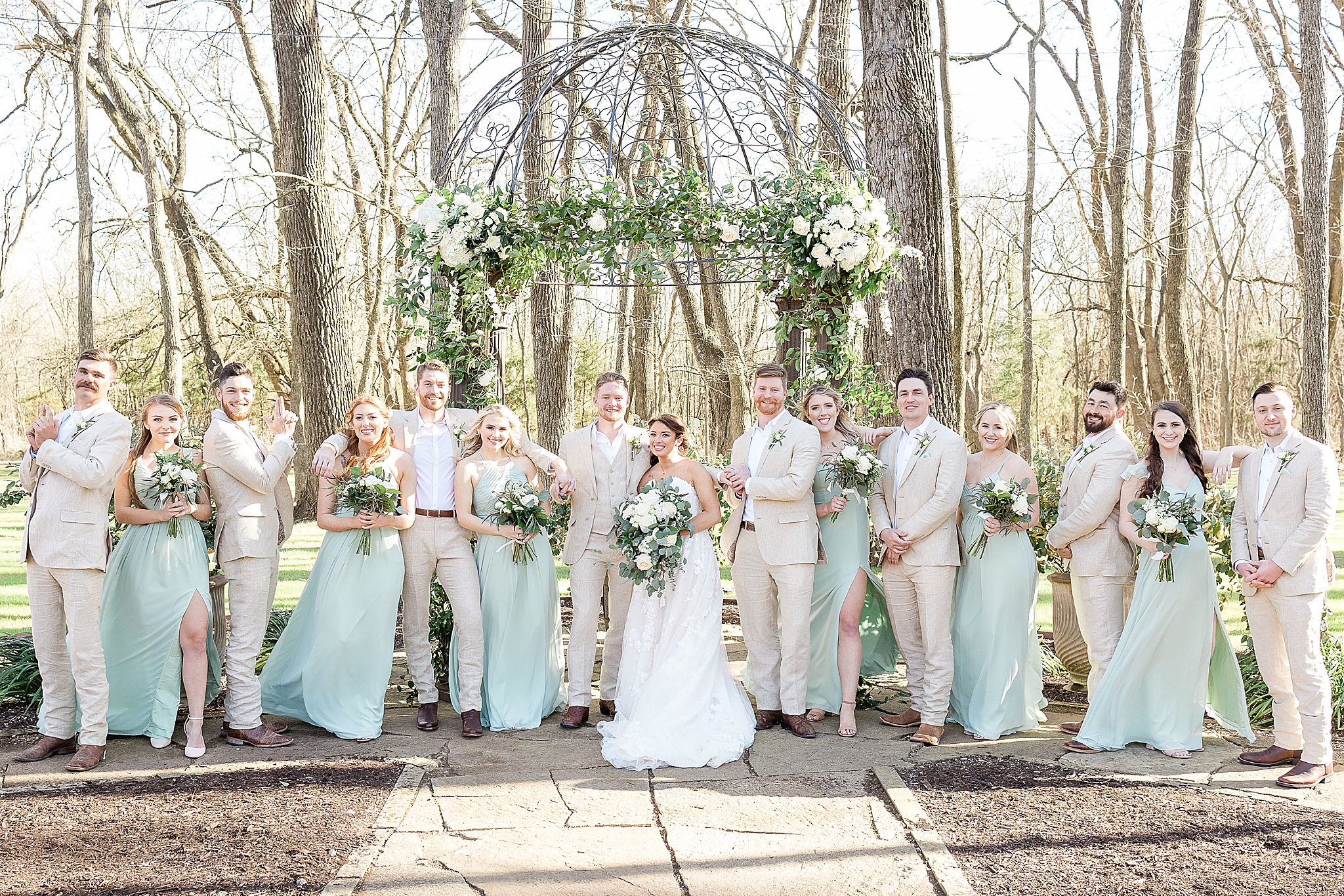 wedding party poses in teal and tan outfits