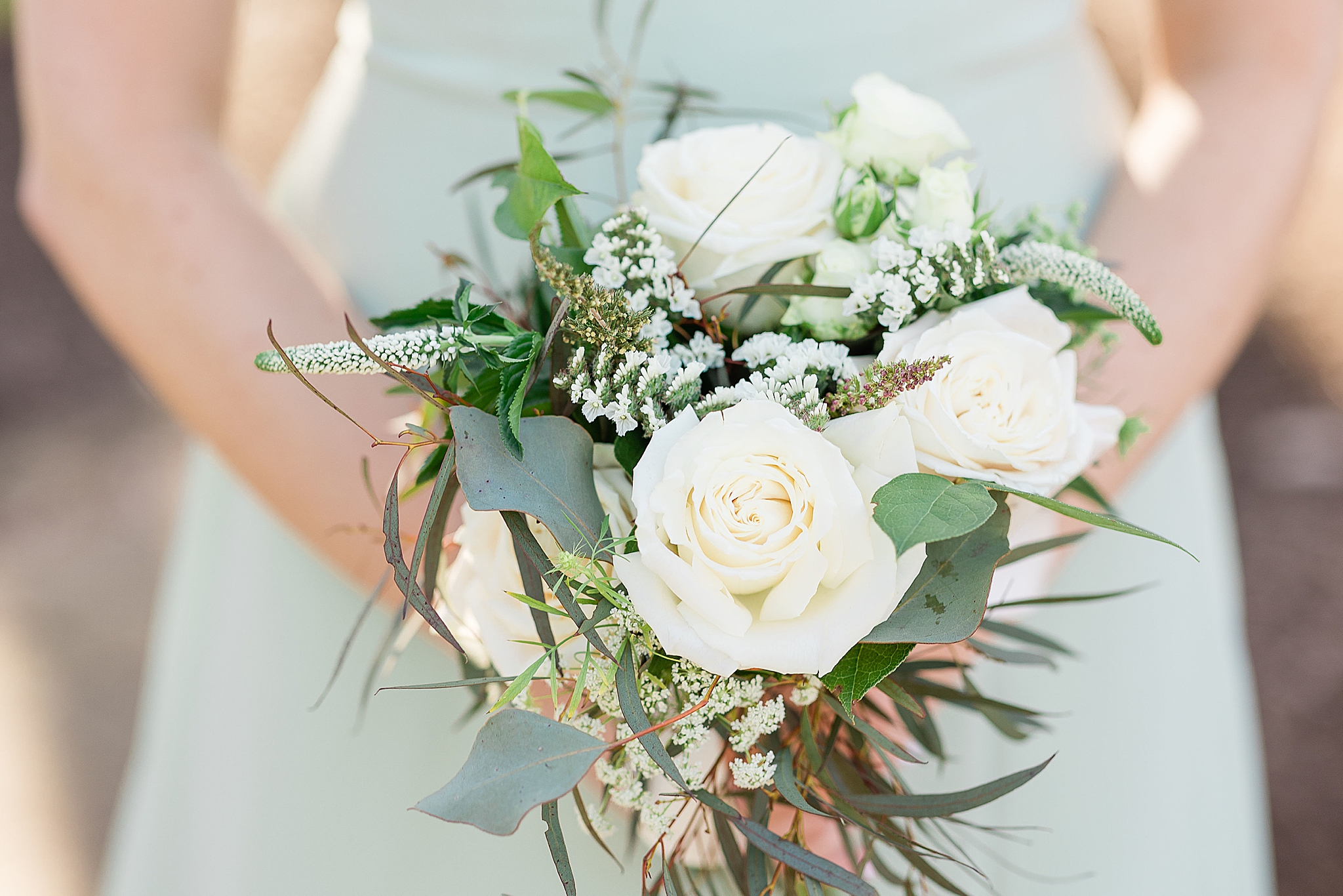 bridesmaid holds bouquet of ivory flowers