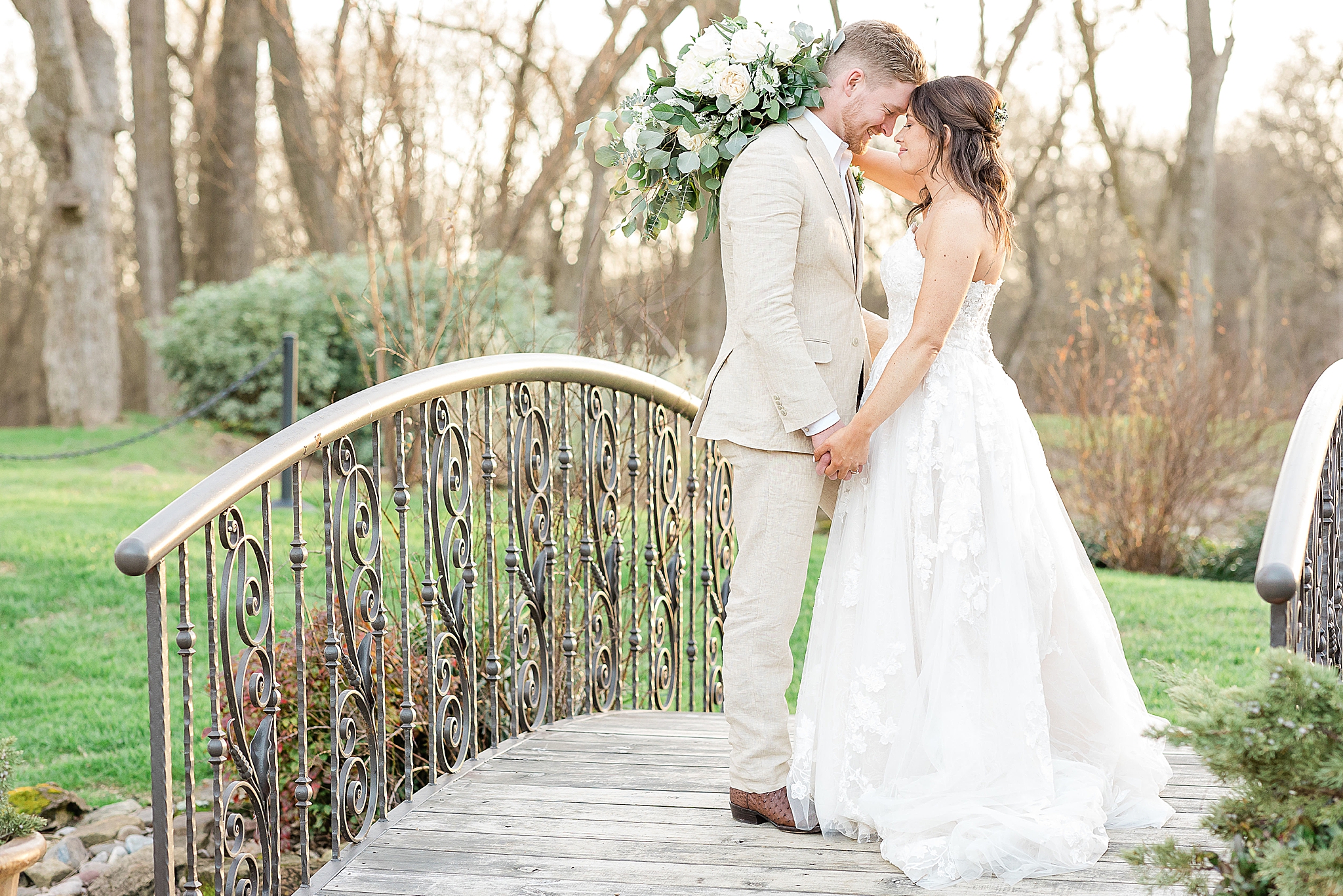 newlyweds pose on wooden bridge