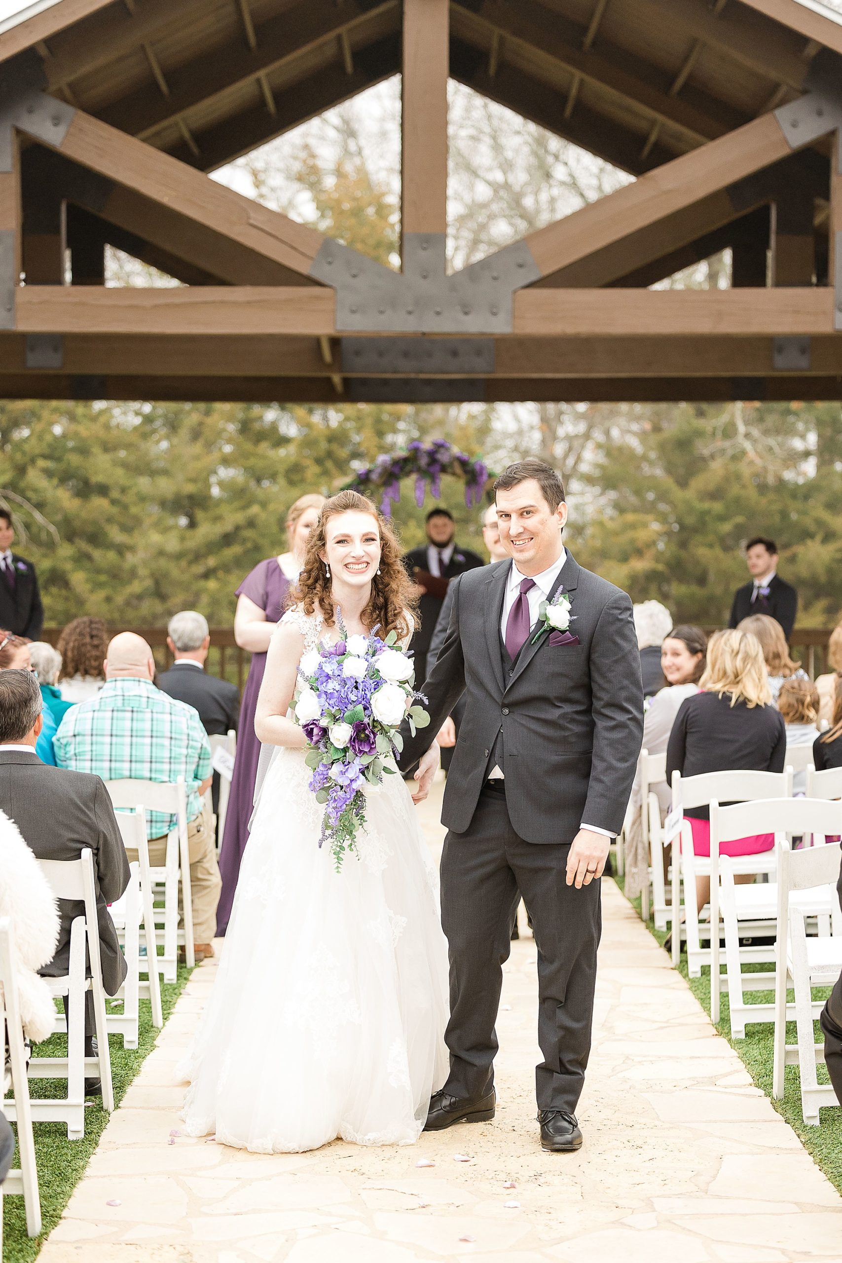 newlyweds leave wedding ceremony at Stone Hall at the Springs