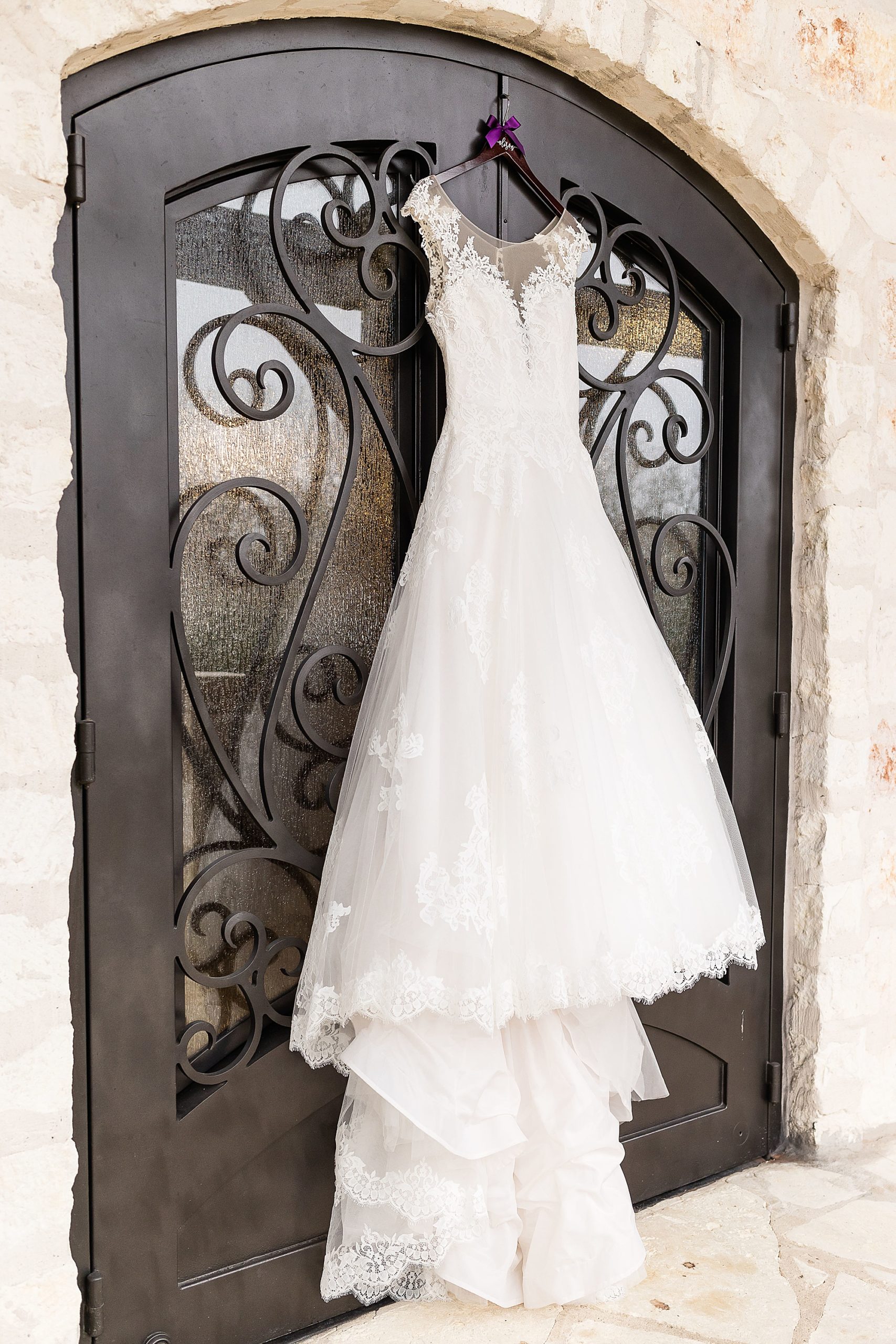 wedding dress hangs on wrought iron door at Anna TX wedding venue