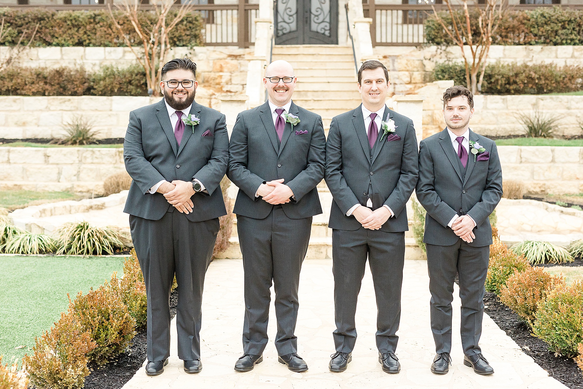 groom and groomsmen stand with arms in front of them