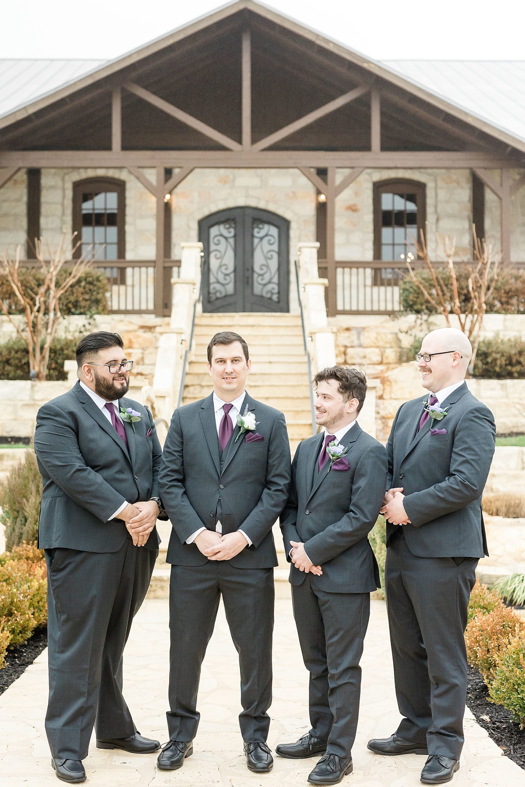 groom laughs with groomsmen during wedding portraits at Stone Hall at the Springs