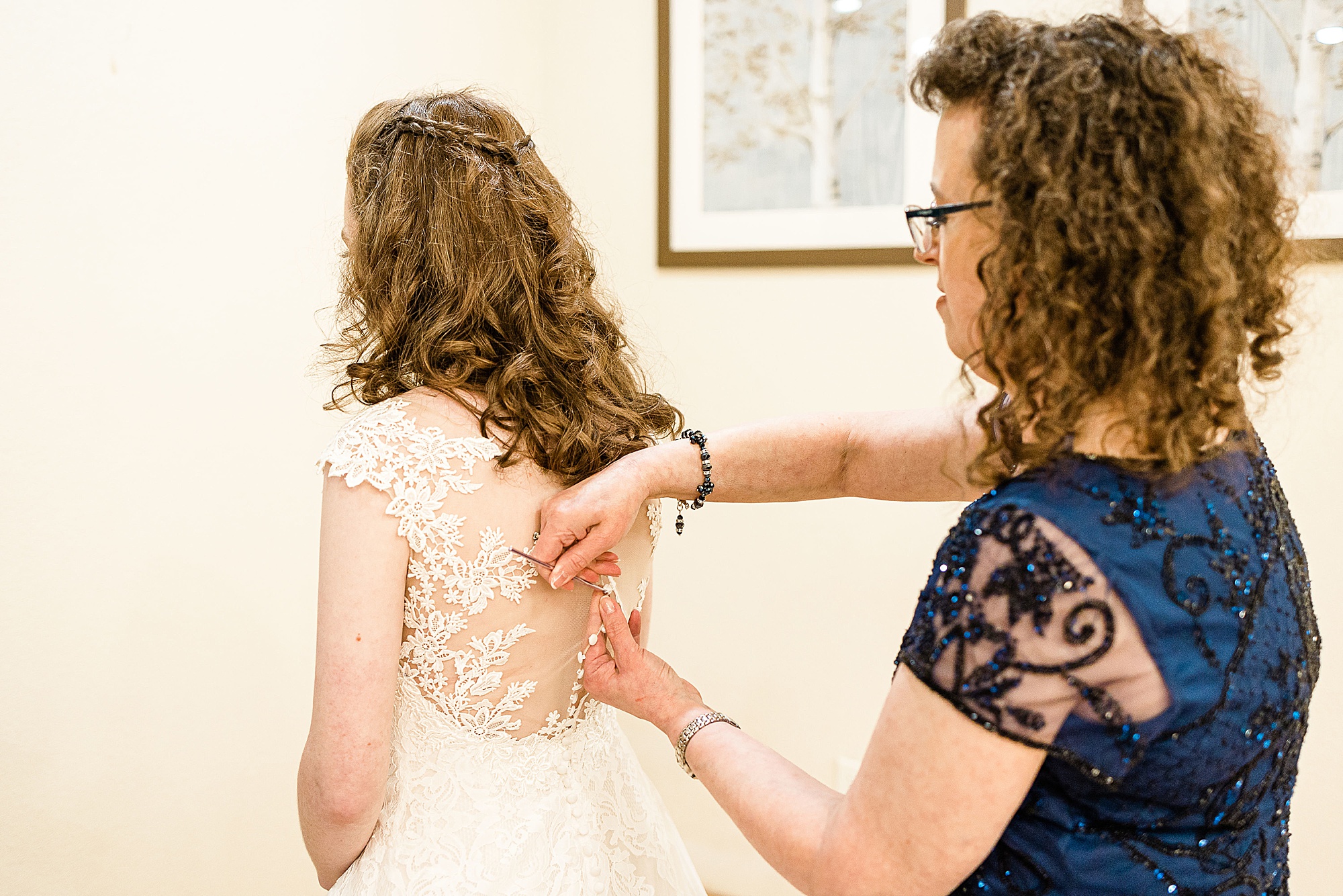 mom adjusts back of wedding gown for Texas bride