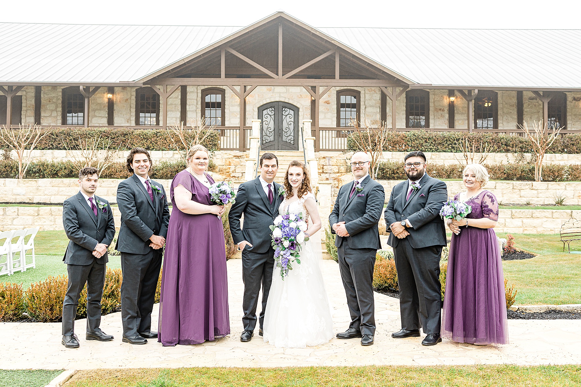 bride and groom pose with wedding party in Texas