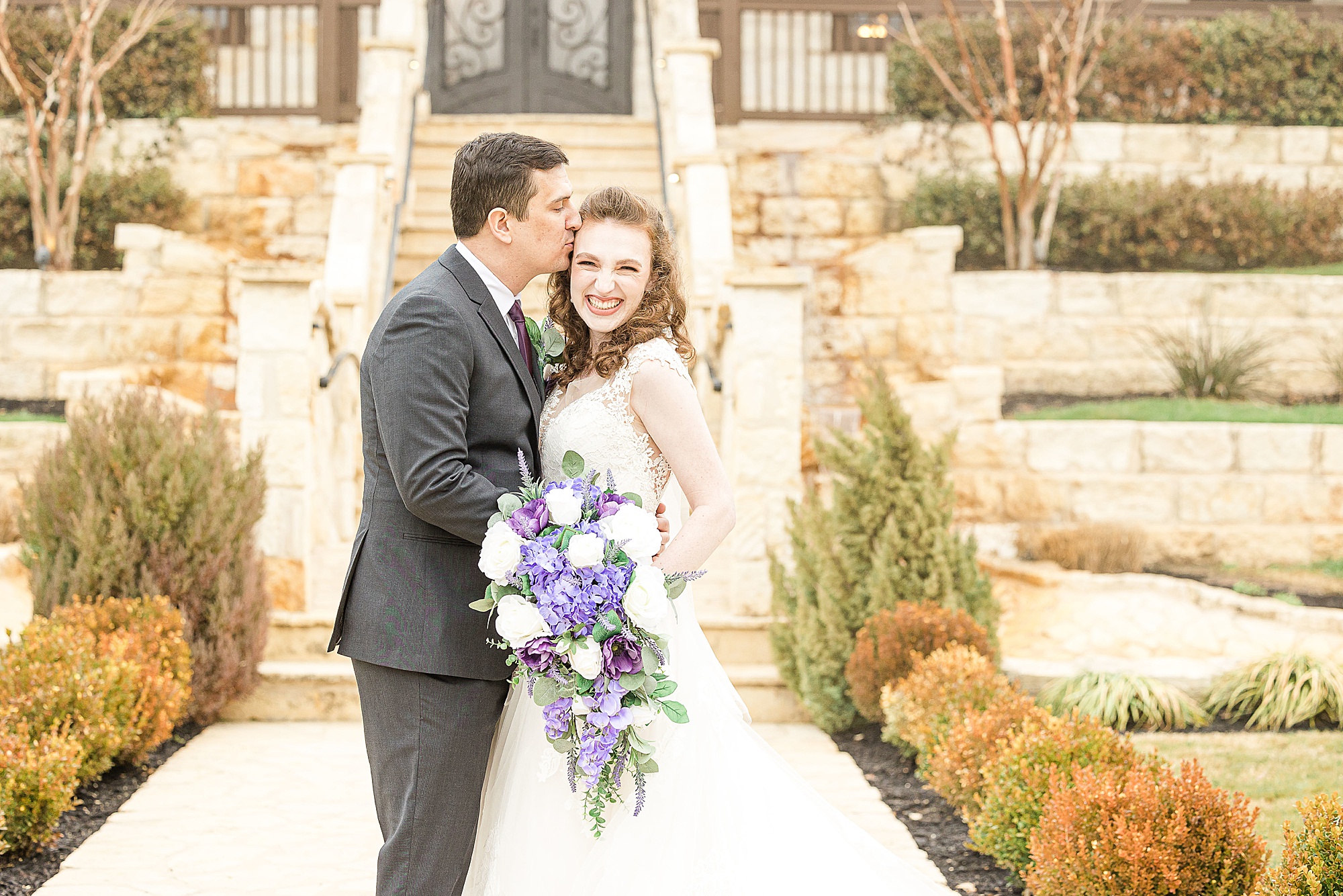 groom kisses bride's forehead during portraits at Stone Hall at the Springs