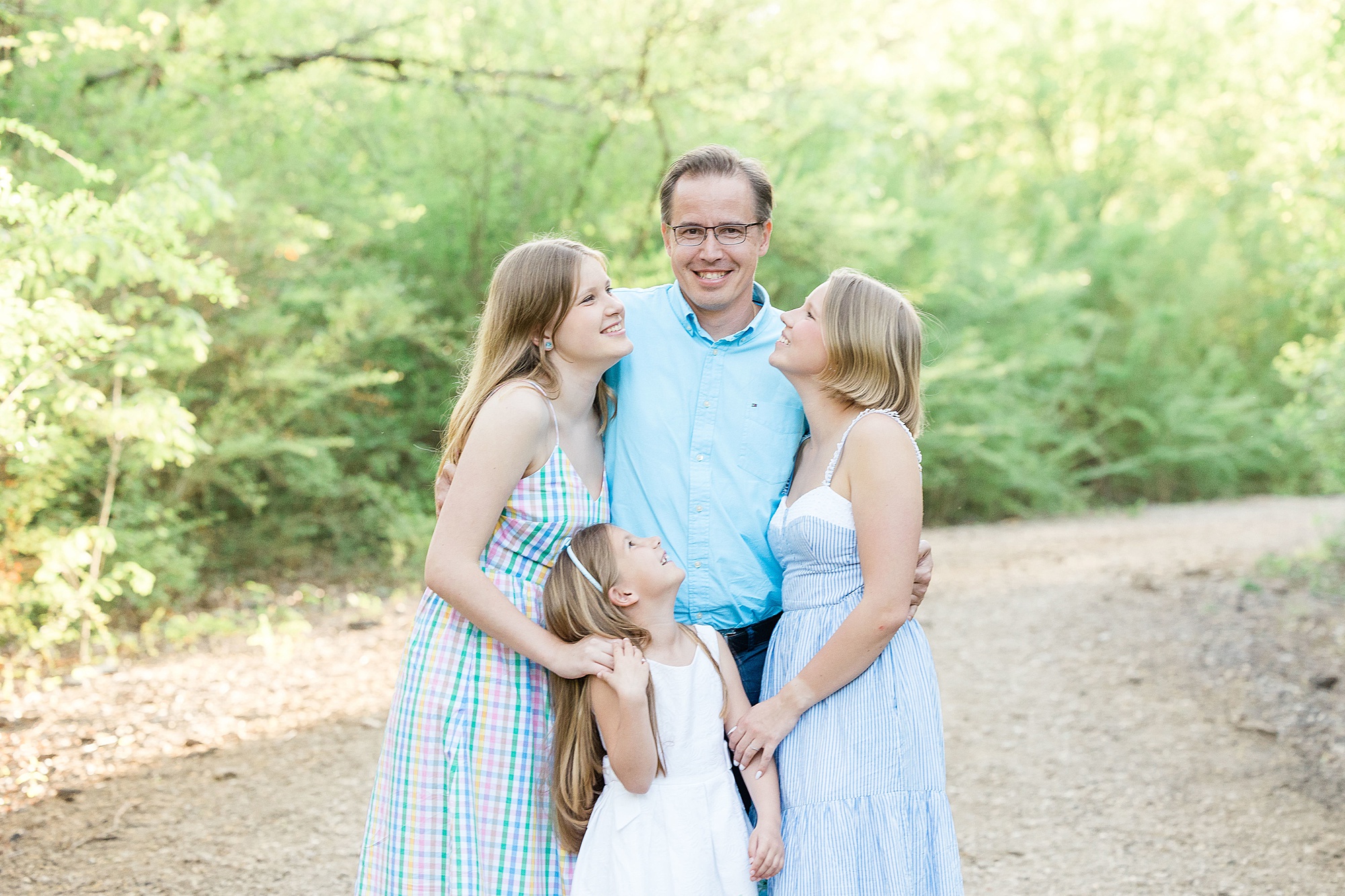 three daughters hug dad during family photos in Texas