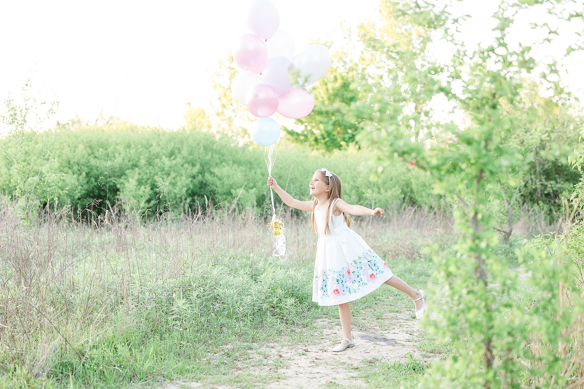 daughter holds balloons in air during TX family photos