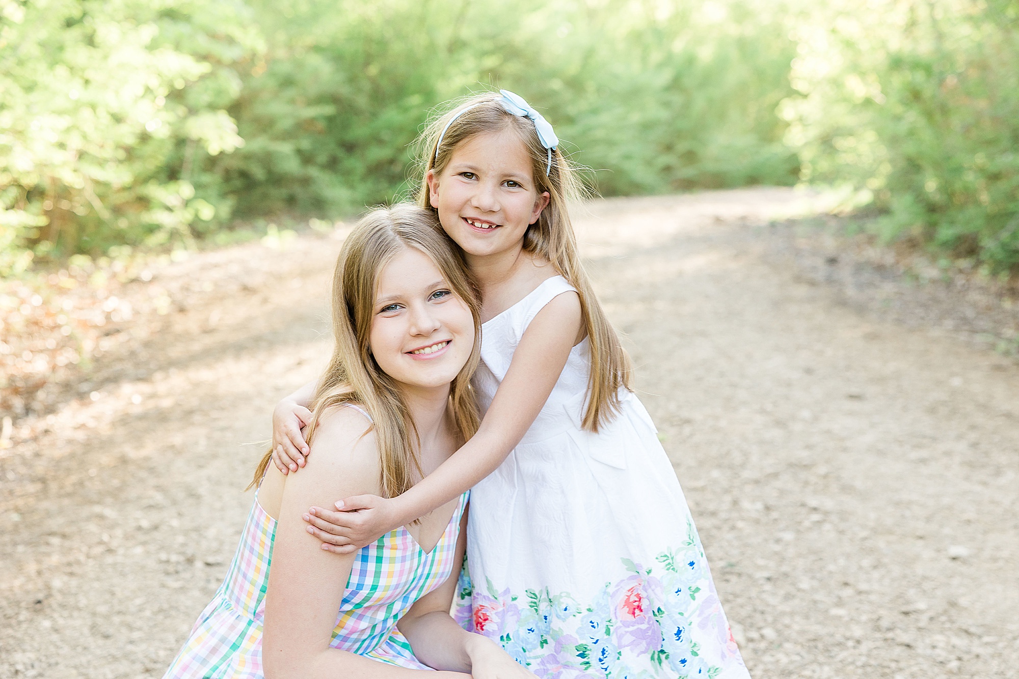 sisters hug during TX family photos at Clear Creek Natural Heritage Center