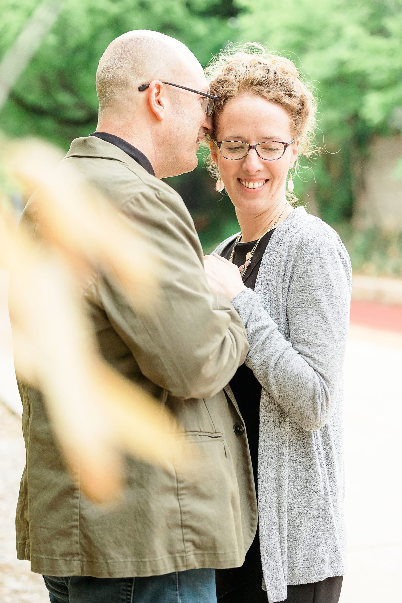 groom whispers in bride's ear during Katy Trail engagement session